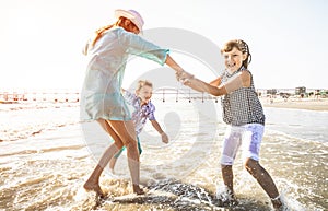 Happy mom playing whit her children with the sea