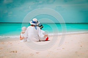 Happy mom with son and daughter hug on beach