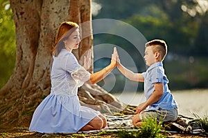 Happy mom and son play in the park in spring. Mother Talking to her son in the park