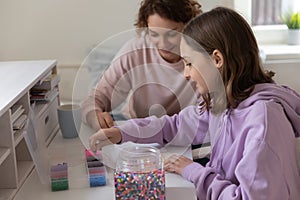 Happy mom and teen daughter play mosaic game at home