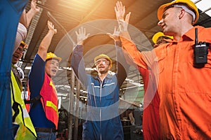 The happy moment industrial worker team in a large industrial factory with many equipment