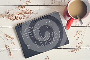 Happy Monday massage on notebook with coffee