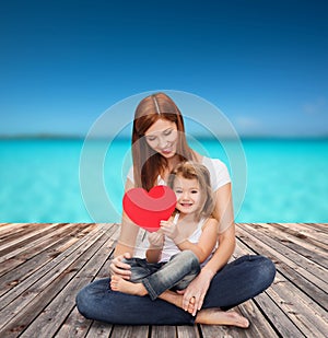 Happy mother with adorable little girl and heart