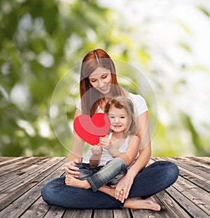 Happy mother with adorable little girl and heart