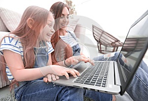 Happy mother with adorable little girl with laptop