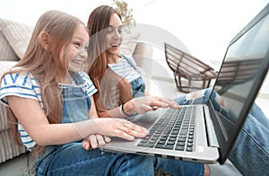 Happy mother with adorable little girl with laptop