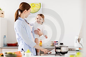 Happy mother and baby cooking at home kitchen