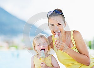 Happy mother and baby eating ice cream