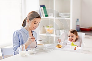 Happy mother and baby having breakfast at home