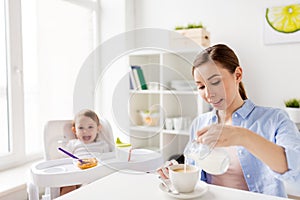 Happy mother and baby having breakfast at home