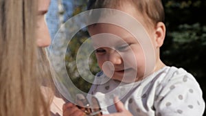 Happy mother and baby outdoors walking in summer day