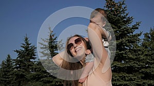 Happy mother and baby outdoors walking in summer day