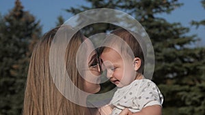 Happy mother and baby outdoors walking in summer day