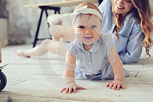 Happy mother and baby playing at home in bedroom