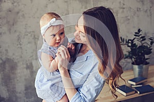 Happy mother and baby playing at home in bedroom