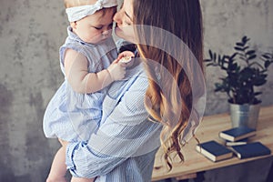 Happy mother and baby playing at home in bedroom