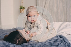 Happy mother and baby playing at home in bedroom. Cozy family lifestyle