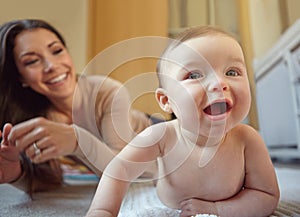 Happy, mother and baby playing in their home together with fun, love and playful bonding. Happiness, smile and young mom