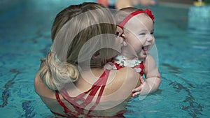 Happy mother with a baby in the pool