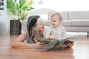 a happy mother with baby reading book