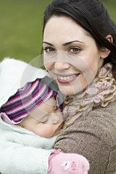 Happy Mother With Baby Sleeping In Her Arms