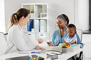 Happy mother with baby son and doctor at clinic