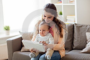 Happy mother with baby and tablet pc at home