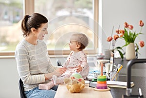 Happy mother with baby working at home office