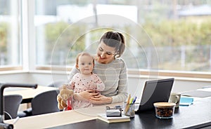 Happy mother with baby working at home office