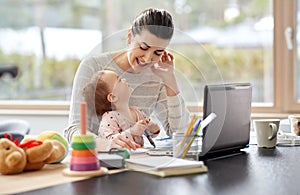 Happy mother with baby working at home office