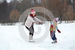 Happy mother catches her cute little son skating