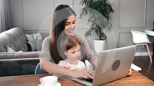 Happy mother chatting typing on keyboard teaching daughter use laptop. Medium shot on RED camera