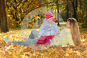 Happy mother with child in autumn park