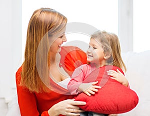 Happy mother and child with big red heart at home