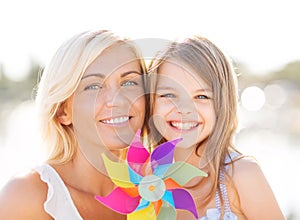 Happy mother and child girl with pinwheel toy