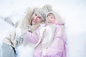 Happy mother and child have fun on snow in winter