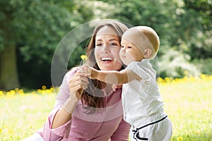 Happy mother and child holding flower in the park