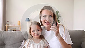 Happy mother and child making video call looking at camera