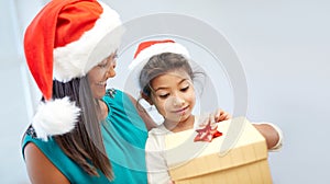 Happy mother and child in santa hats with gift box