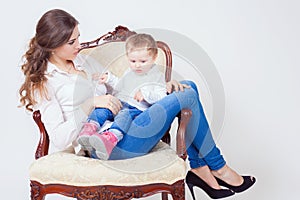 Happy mother and child sitting at armchair home