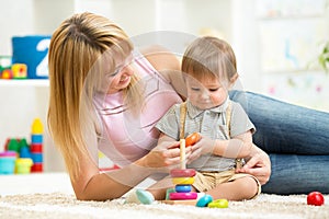 Happy mother and child son play together indoor at