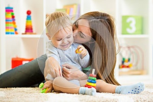 Happy mother and child son playing indoor at home