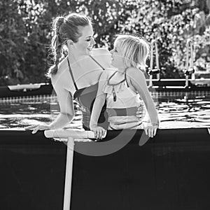 Happy mother and child in swimming pool looking at each other