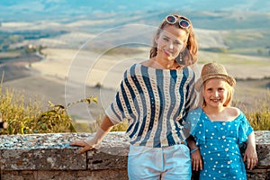 Happy mother and child tourists against scenery of Tuscany