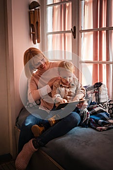 Happy mother with child using digital tablet at home. People technology family happiness concept.