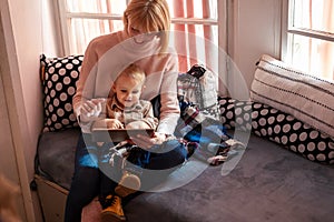 Happy mother with child using digital tablet at home. People technology family happiness concept.