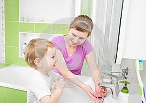 Happy mother and child washing hands with soap together