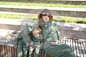 Happy mother with children in fashionable clothes family look in a park