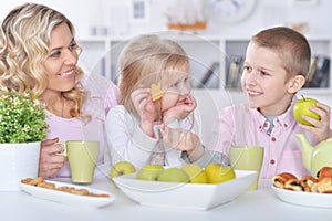 Happy mother and children having breakfast together