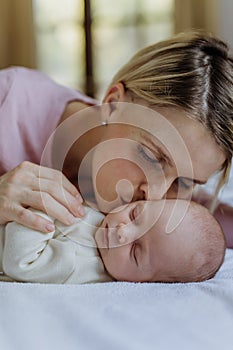 Happy mother cuddling her little newborn baby.